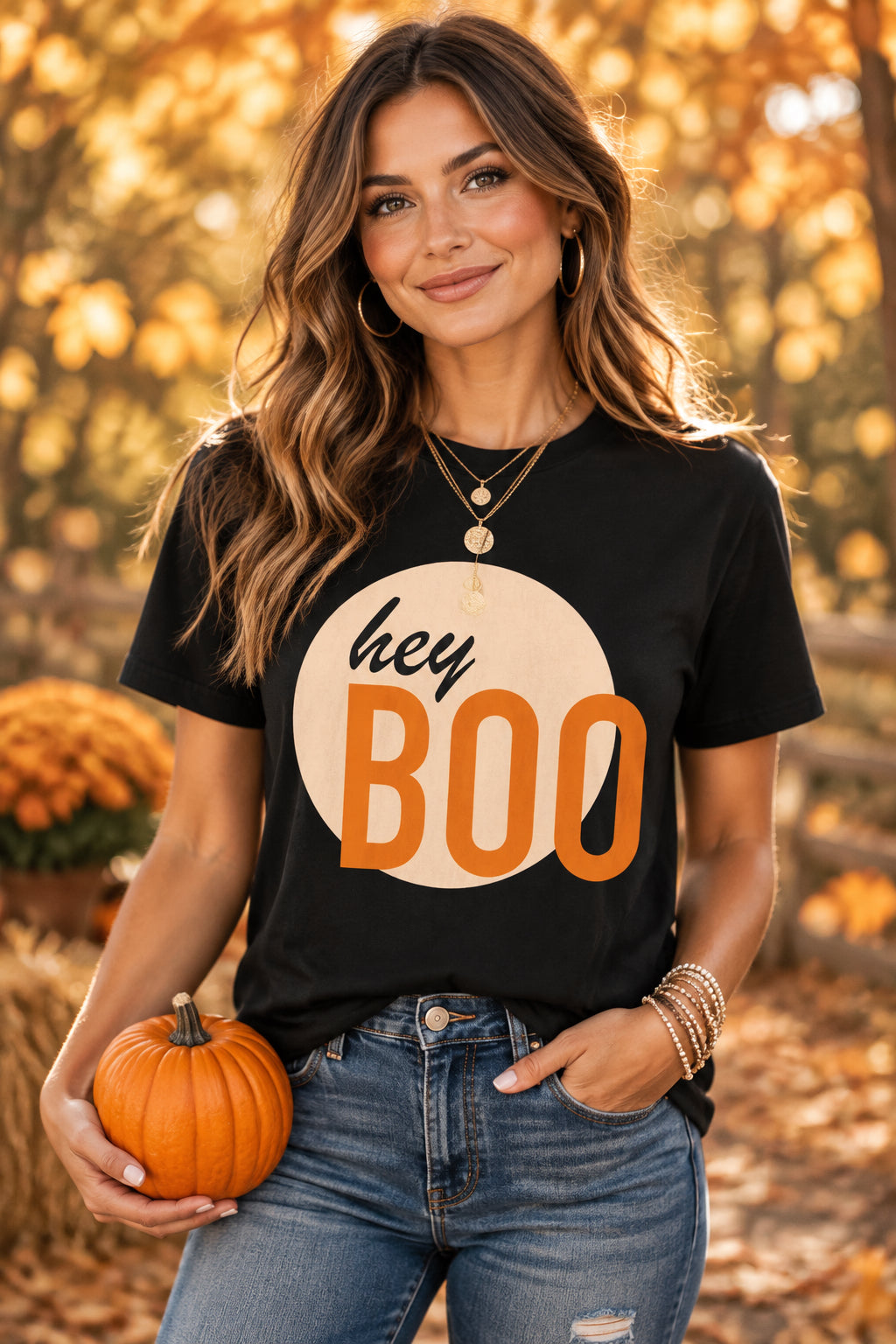 A black short-sleeve crewneck t-shirt featuring a graphic print of a peach-colored circle with the words 'hey BOO' in black and orange lettering, displayed on a clean white background.